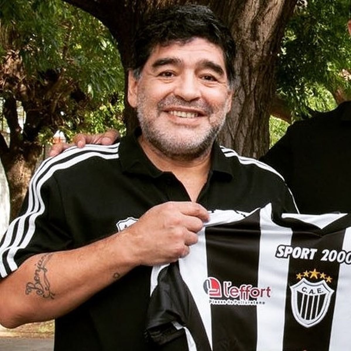Diego Armando Maradona posando con una camiseta de Estudiantes de Caseros.